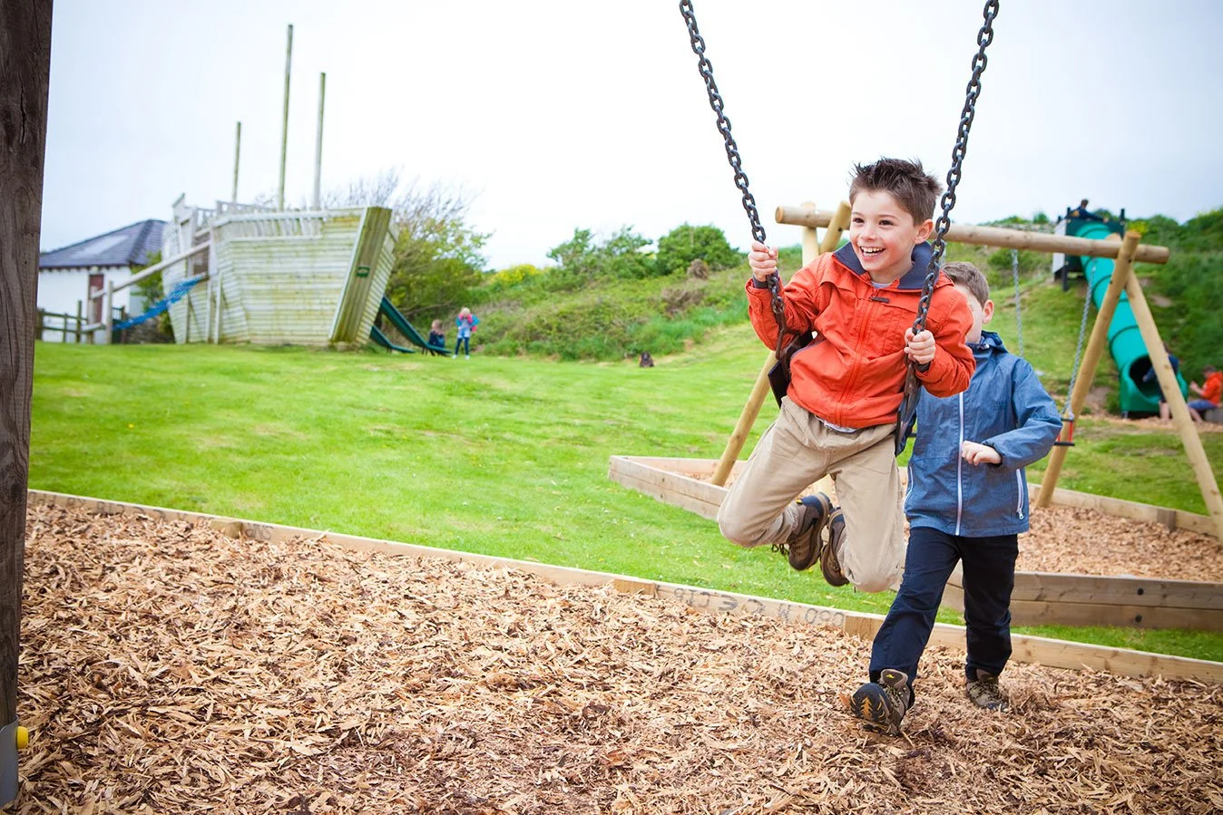 Children playing on the swings in the play area at Silver Bay