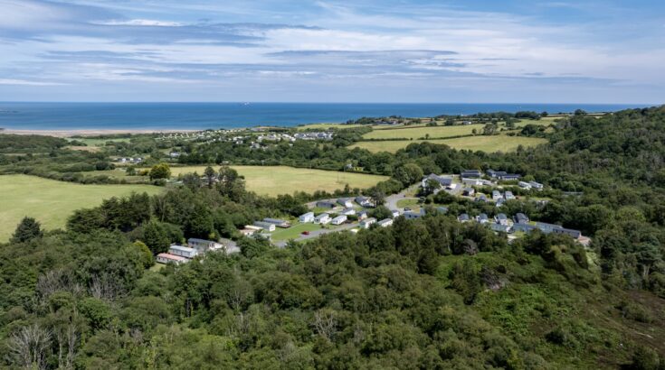 Woodland Falls among the trees, with the sea beyond
